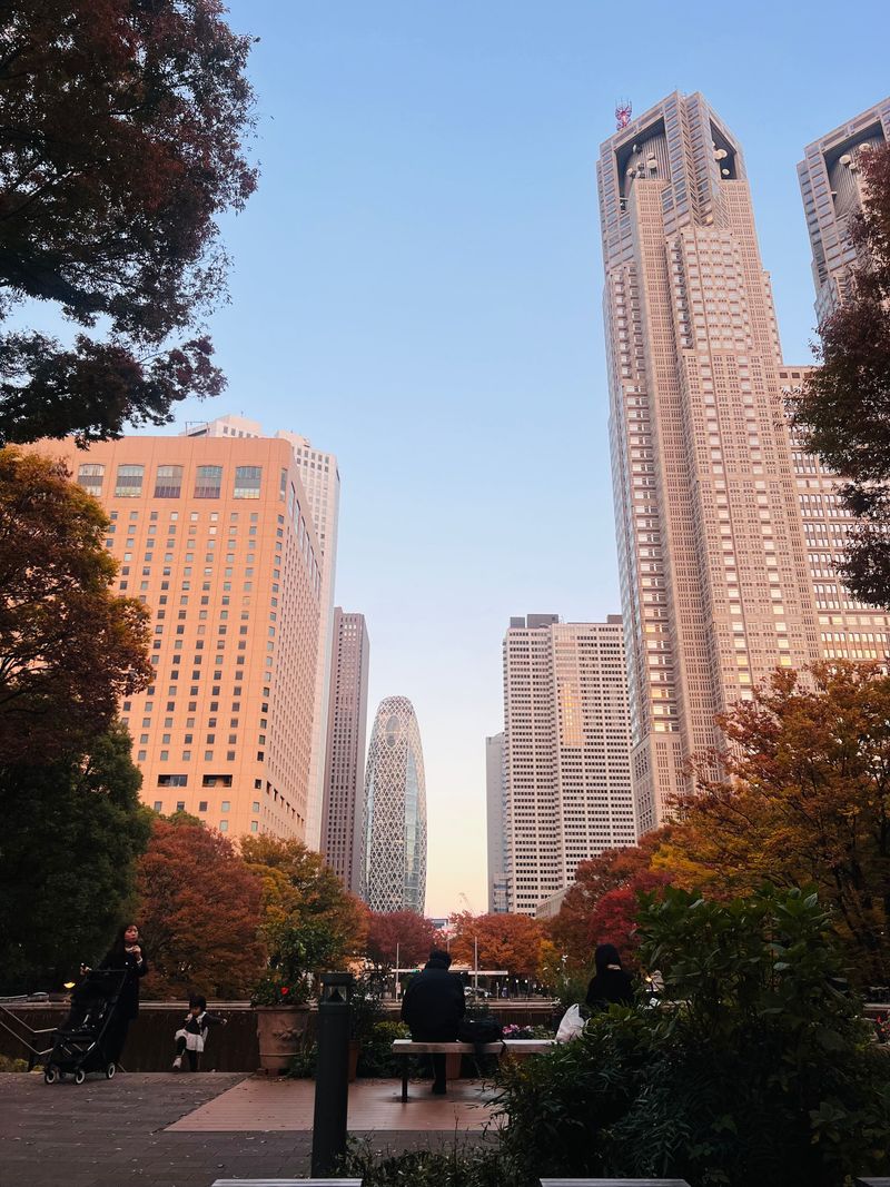 Skyscrapers seen through vivid orange autumn foliage