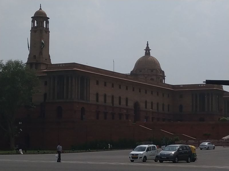 The red sandstone domes of Rashtrapati Bhavan with street traffic below