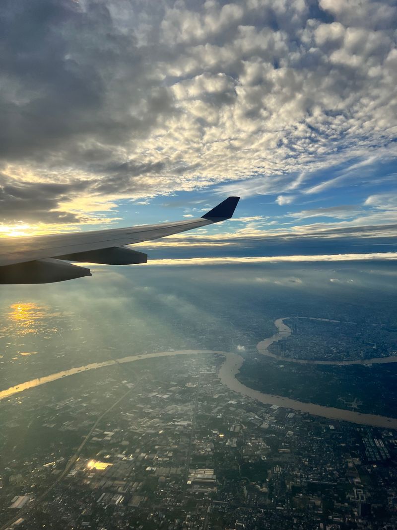 An airplane wing floating above a blanket of clouds