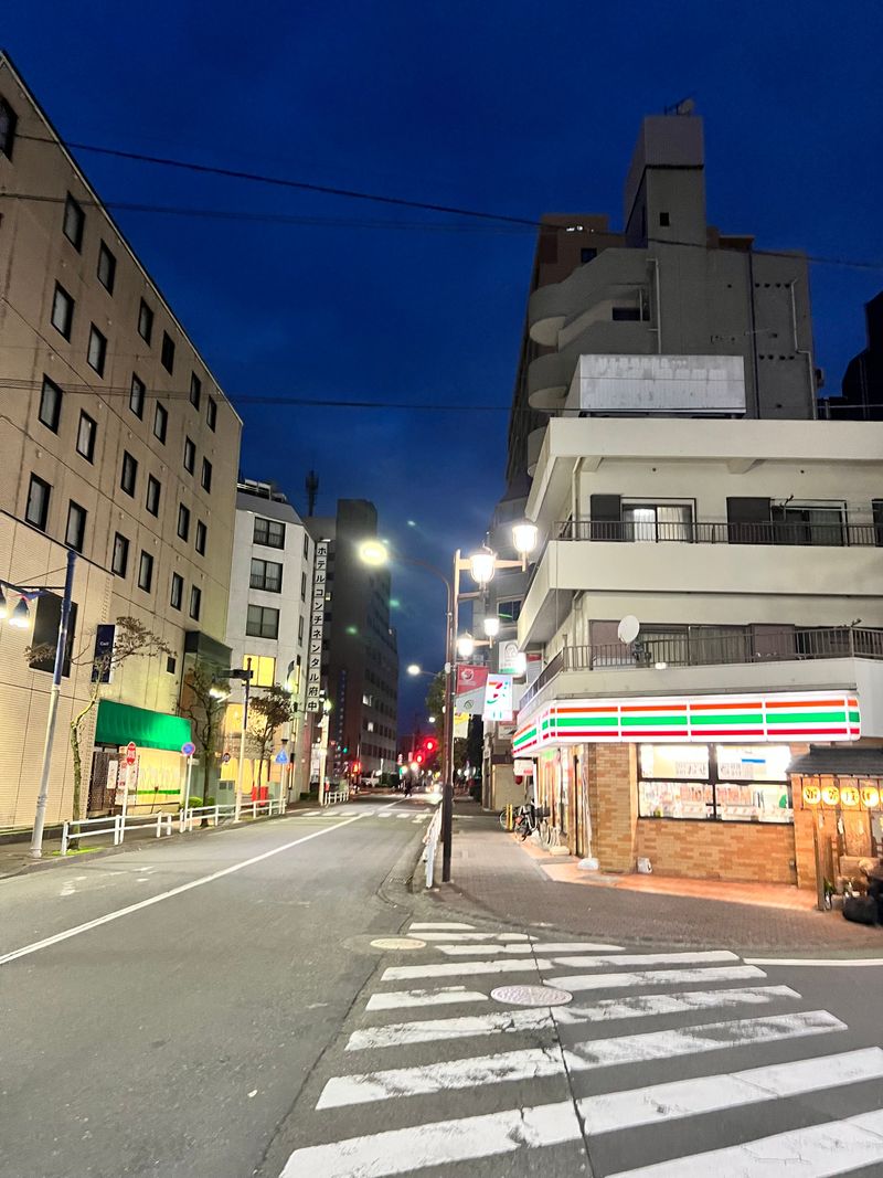 A quiet city street under the deep blue evening sky