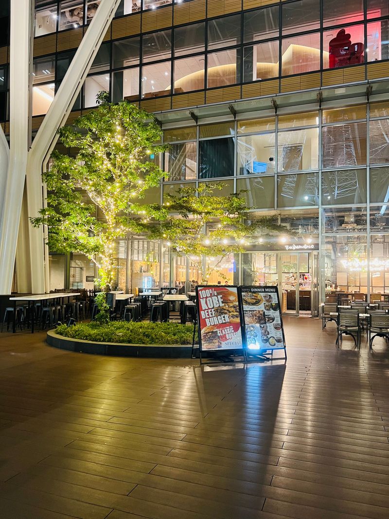 A modern glass building reflected in a pool at night